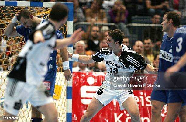 Markus Ahlm of Kiel celebrates while Sverre Andreas Jakobsson and Geoffroy Krantz look dejected during the Handball Bundesliga game between VfL...