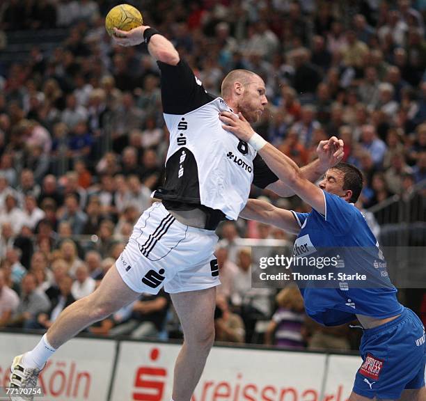 Momir Ilic of Gummersbach tackles Ales Pajovic of Kiel during the Handball Bundesliga game between VfL Gummersbach and THW Kiel at the Koelnarena on...