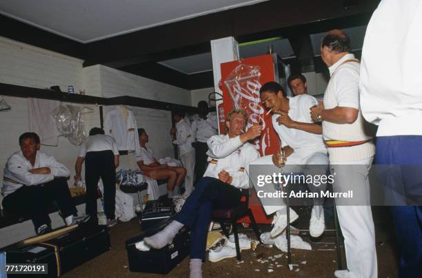 Graham Dilley lights a cigarette for Phil DeFreitas in the England dressing room, after the team beat Australia by seven wickets in the 1st Test on...