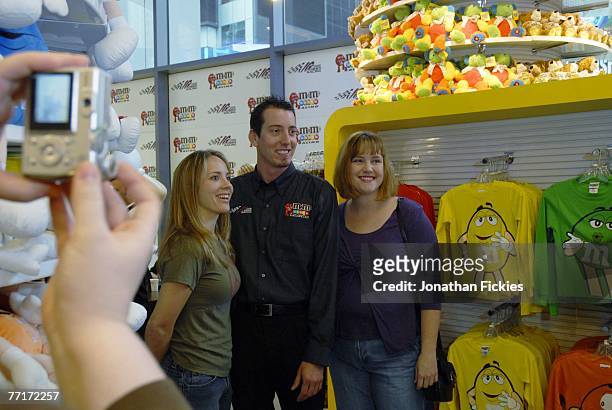 Driver Kyle Busch poses for a photo with fans Dawn Carver and Hope Gardner , of South Carolina, after unveiling the new 2008 M&M's Racing Toyota...