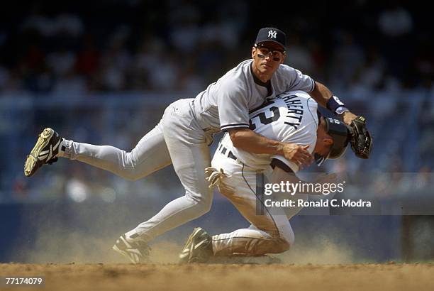 Randy Velarde of the New York Yankees falls over John Flaherty of the Detroit Tigers after throwing to first base during a MLB game on September 23,...