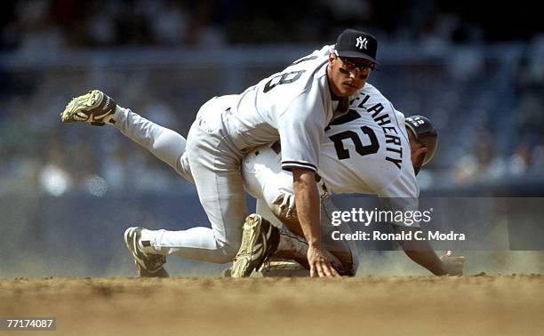 Randy Velarde of the New York Yankees falls over John Flaherty of the Detroit Tigers after throwing to first base during a MLB game on September 23,...
