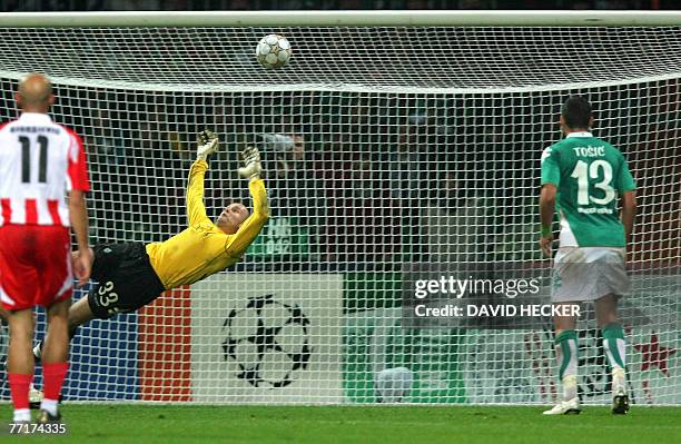 Werder Bremen's goalkeeper Christian Vander dives in vain for the ball while Olympiacos' midfielder Predrag Djordjevic and Weder Bremen's Serbian...