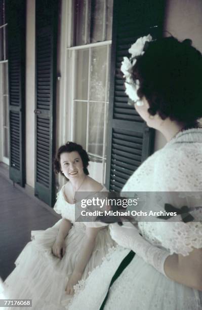 Southern Belles chat on the porch during a recreation of pre Civil War life on a plantation circa mid 1930's in the deep south.