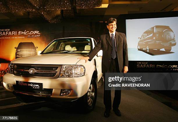 President of India's Tata Motors passenger car division Rajiv Dube gestures as he poses in front of a New Safari DICOR 2.2 VTT automobile during a...
