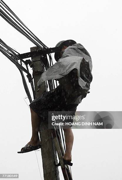 Soldier ties up telecommunication cables on a pole in the central city of Vinh, hours before tropical typhoon Lekima was due to hit central Vietnam,...