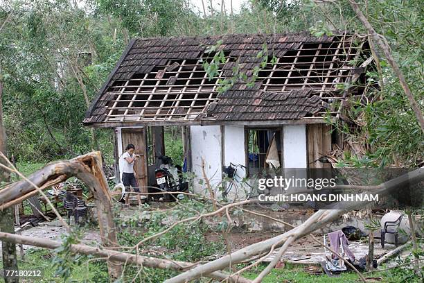 Woman walks in front of her damaged house after the passage of tropical storm Lekima, at Cam Xuyen district, in the central province of Ha Tinh, 04...