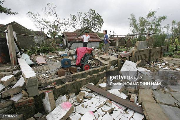 Residents stand at a completely destroyed house after the passage of tropical storm Lekima at Ky Anh district, in the central province of Ha Tinh, 04...