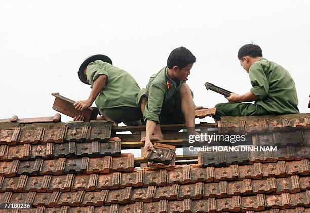 Soldiers help repair the damaged roof of a house after the passage of the tropical storm Lekima, at Ky Anh district, in the central province of Ha...