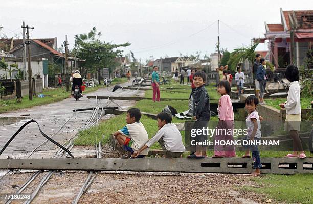 Children sit on an electrical pole which fell down after the passage of the tropical storm Lekima at Ky Anh district, in the central province of Ha...