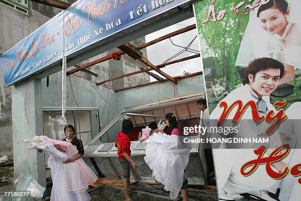 Employees of a wedding dress shop clean their damaged outlet, after the passage of the tropical storm Lekima at Ky Anh district, in the central...
