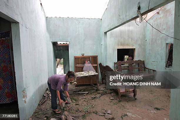 Nguyen Thi Mai cleans up her damaged house after the passage of tropical storm Lekima at Cam Xuyen district, in the central province of Ha Tinh, 04...
