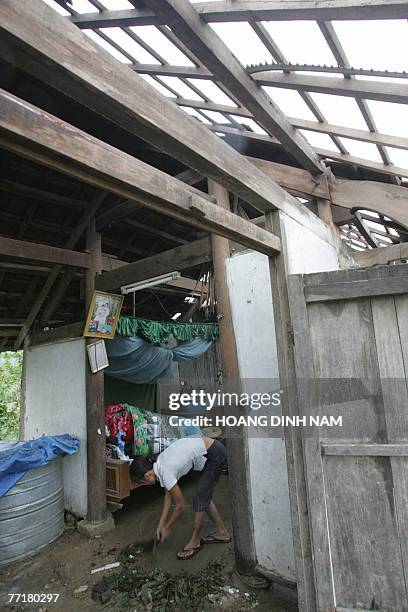 Nguyen Thi Loan cleans up her damaged house after the passage of the tropical storm Lekima at Cam Xuyen district, in the central province of Ha Tinh...