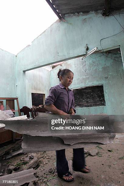 Nguyen Thi Mai cleans up her damaged house after the passage of tropical storm Lekima at Cam Xuyen district, in the central province of Ha Tinh, 04...