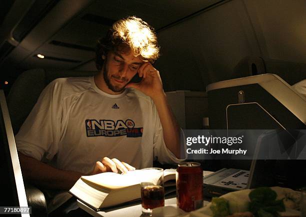 Pau Gasol of the Memphis Grizzlies reads a book on board the team plane for Malaga, Spain for EA Sports NBA Europe Live Tour on October 4, 2007 in...