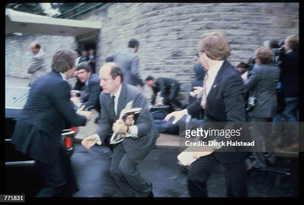 Deputy Chief of Staff Michael Deaver flees as chaos ensues immediately after the March 30, 1981 assassination attempt on President Reagan by John...