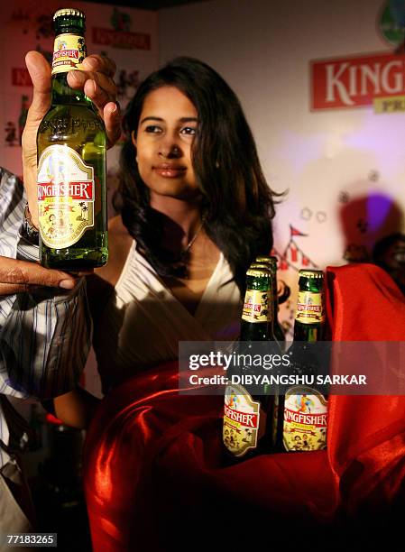 An Indian models gestures as she holds bottles of Kingfisher beer during the launch of commemorative packs of 'Indian October Fest' beer bottles in...