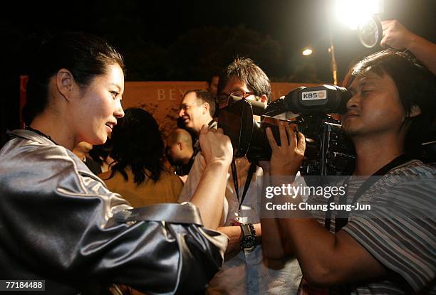 Actress Moon So-Ri signs her autograph on the camera at the opening ceremony party for the 12th Pusan International Film Festival October 4, 2007 in...