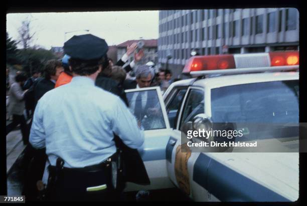 Authorities place John Hinkley Jr. Into a police car shortly after his attempt to assassinate President Reagan on March 30, 1981 outside the Hilton...