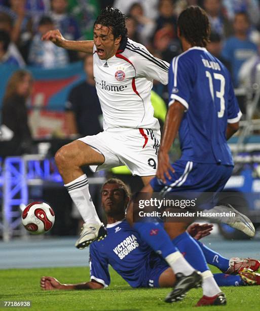 Luca Toni of Munich fights for the ball with Hugo Alcantara of Lisbon and his team mate Rolando during the first round second leg UEFA cup match...