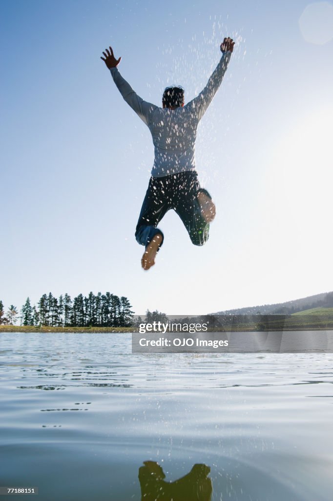 A man jumping overtop of water