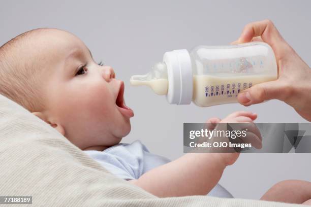 ein baby tierfütterung eine flasche - cute baby studioshot stock-fotos und bilder