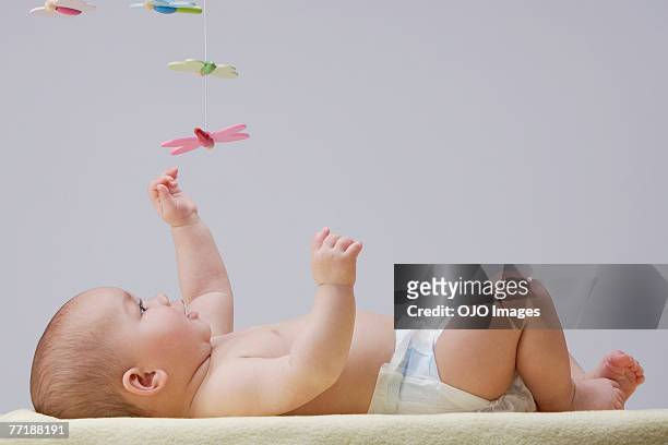 baby spielt mit mobile - cute baby studioshot stock-fotos und bilder