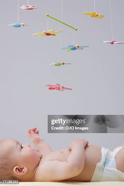 um bebê brincando com um telemóvel - mobile imagens e fotografias de stock