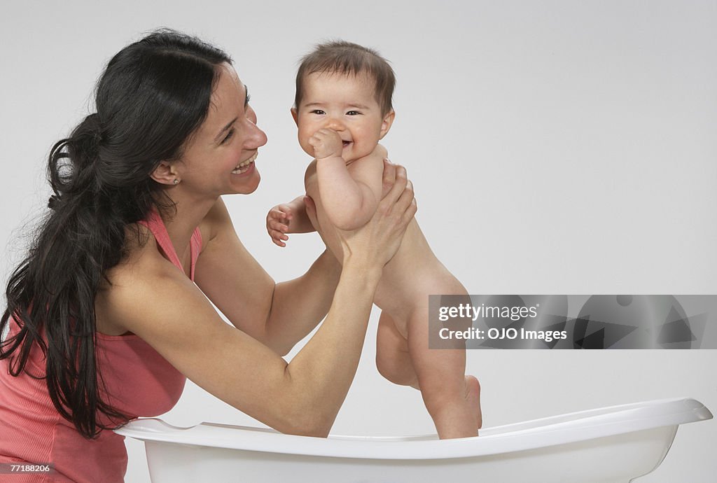 A woman giving a baby a bath