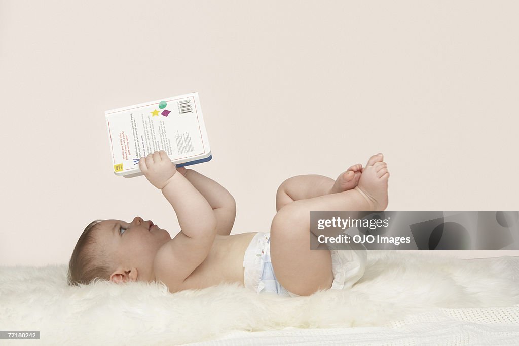 A baby looking at a book