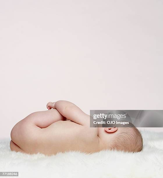 a baby lying down - blote jongens stockfoto's en -beelden