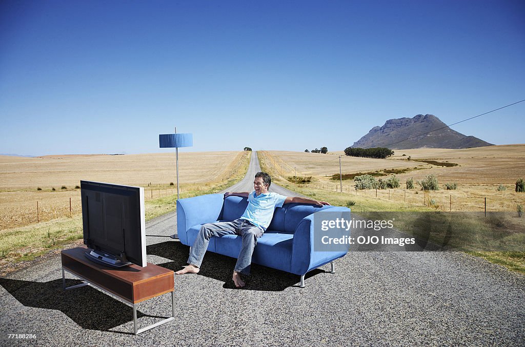 Ein Mann vor dem Fernseher auf der couch in die road