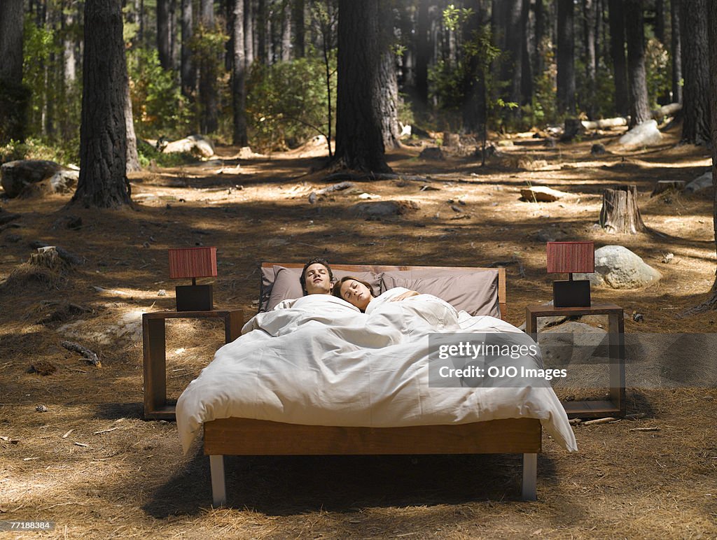 Coppia di dormire nel letto all'aperto nel bosco