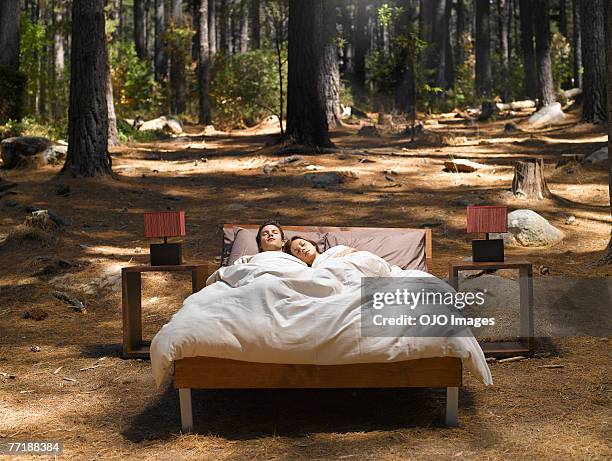 a couple sleeping in a bed outdoors in the woods - crazy girlfriend stock pictures, royalty-free photos & images