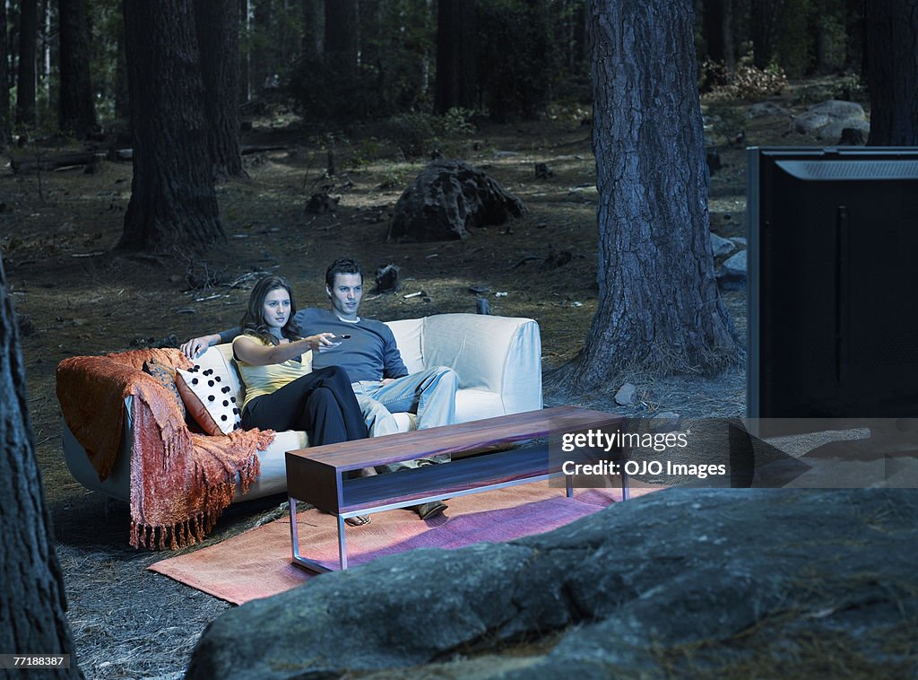 Una Pareja mirando televisión al aire libre en el bosque