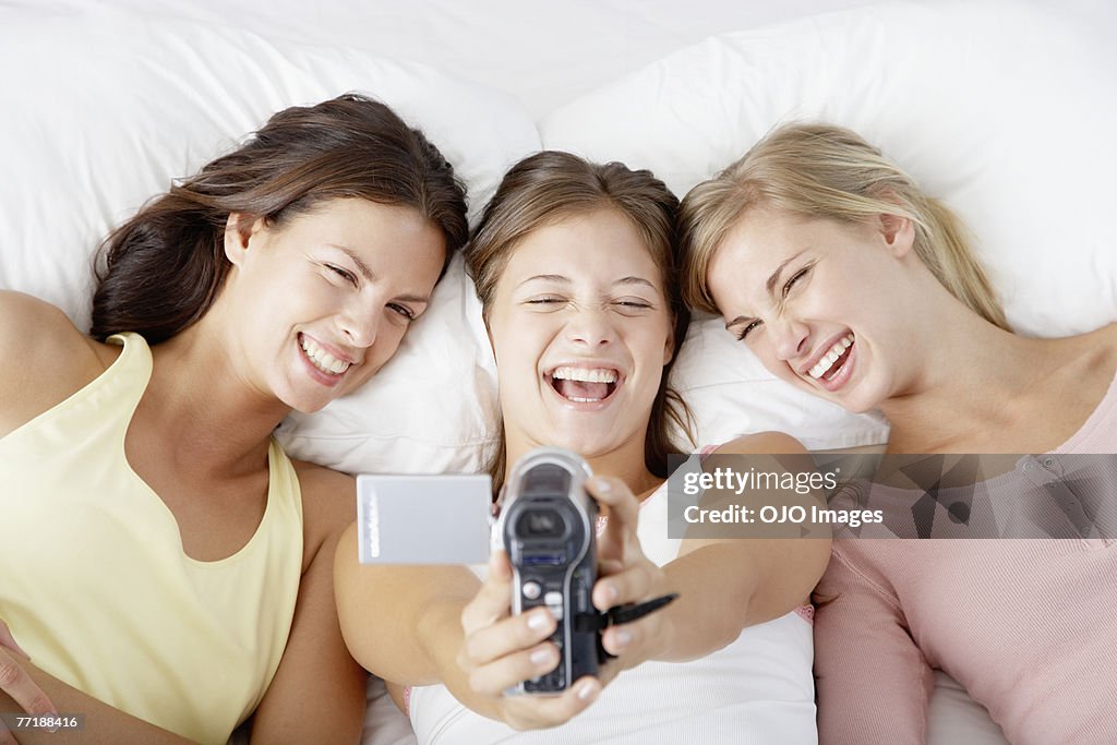 Three girlfriends using a camcorder