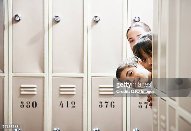students peeking around lockers - kid peeking stock pictures, royalty-free photos & images