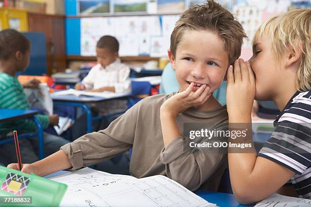 schüler in klasse flüstern - child whispering stock-fotos und bilder