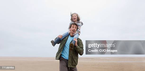 a man and child at the beach - piggyback stock pictures, royalty-free photos & images