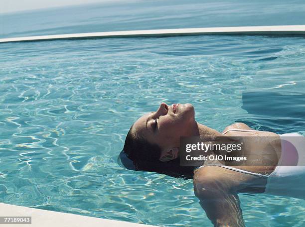 eine frau entspannen im wasser - women by pool stock-fotos und bilder