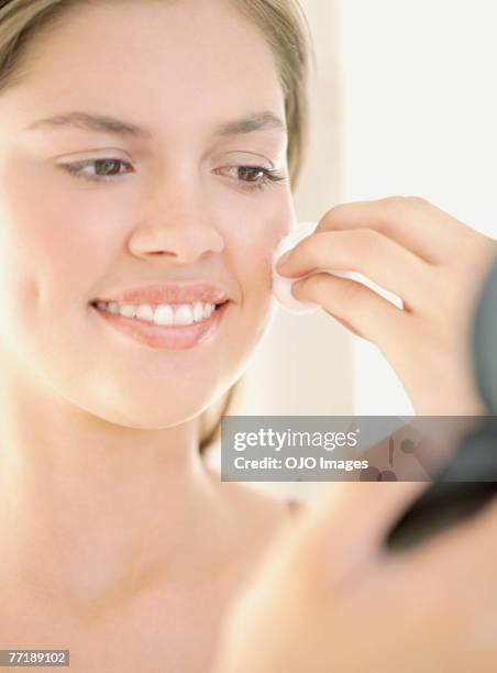 a woman applying make-up - woman applying cotton ball stock pictures, royalty-free photos & images