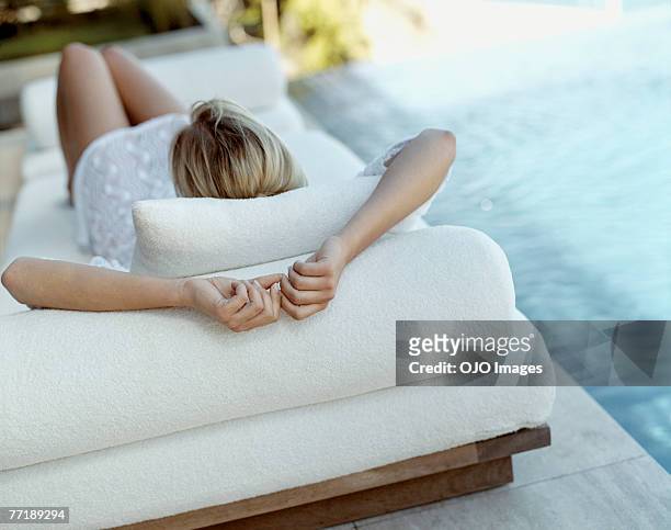una donna sdraiata in piscina - sitting back foto e immagini stock