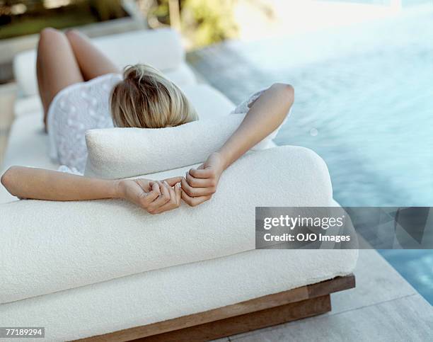 a woman lying by the pool - achterover leunen stockfoto's en -beelden