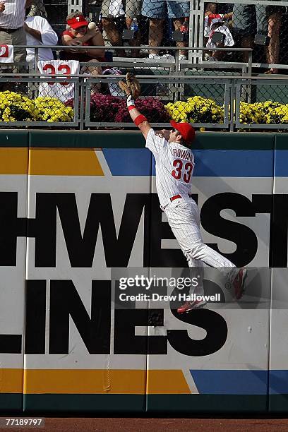 Aaron Rowand of the Philadelphia Phillies fails to steal a solo home run hit by Troy Tulowitzki of the Colorado Rockies during Game Two of the...
