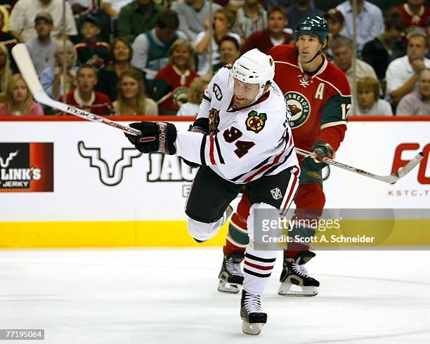 Yanic Perreault of the Chicago Blackhawks takes a shot as Brian Rolston of the Minnesota Wild watches October 4, 2007 at the Xcel Energy Center in...