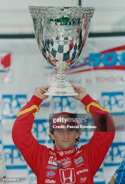 Alex Zanardi of Italy and driver of the Target Chip Ganassi Racing Reynard 97i Honda lifts the The Vanderbilt Cup designed and produced by Tiffany...