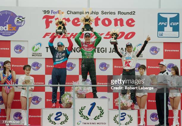 Adrian Fernandez of Mexico and driver of the Patrick Racing Tecate Quaker State Reynard 99iFord XD celebrates with second placed Gil de Ferran and...