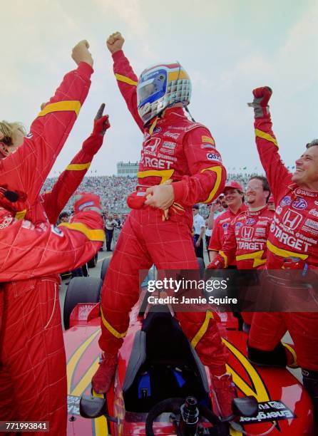 Alex Zanardi of Italy and driver of the Target Chip Ganassi Racing Reynard 98i Honda stands on top of his car and celebrates with his crew after...