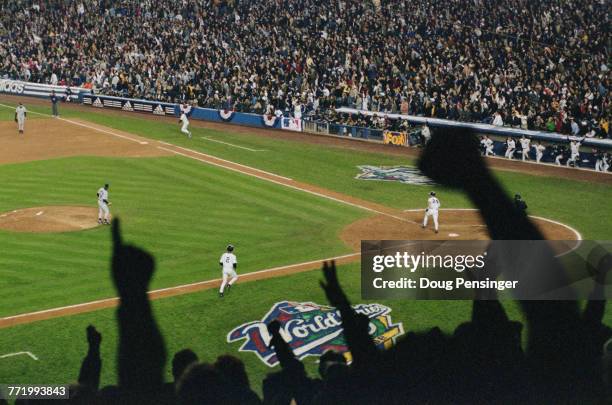 The crowd of spectators celebrate asTino Martinez of the New York Yankees sends a grand slam home run into the upper deck during Game One of the...