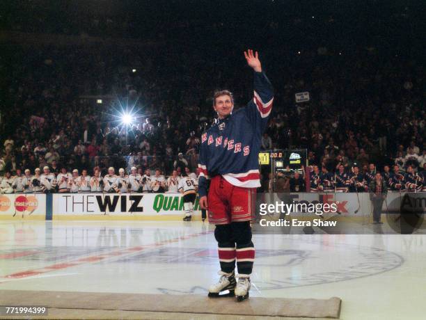 The crowd of spectators, players and team mates applaud as Wayne Gretzky of the New York Rangers waves in salute on his retirement after the National...